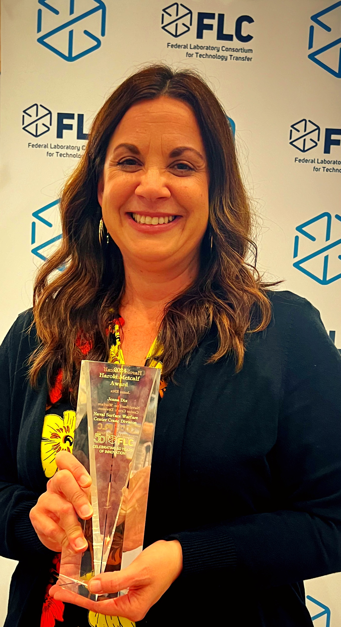 Jenna Dix, NSWC Crane Director of Engagement, receiving the Federal Laboratory Consortium Harold Metcalf Award Jenna Dix, NSWC Crane Director of Engagement, receiving the Federal Laboratory Consortium Harold Metcalf Award